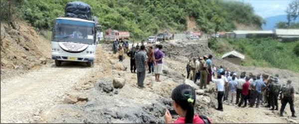 A bus negoitiates over the sunk portion of NH-39