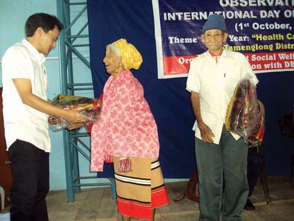 Joseph Pauline, ADM and ED DRDA Tamenglong presenting gifts to elderly persons on Old Age Day