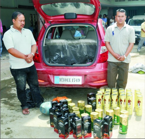 Two persons overpowered from near the Minister's residence paraded before the media along with the seized IMFL bottles
