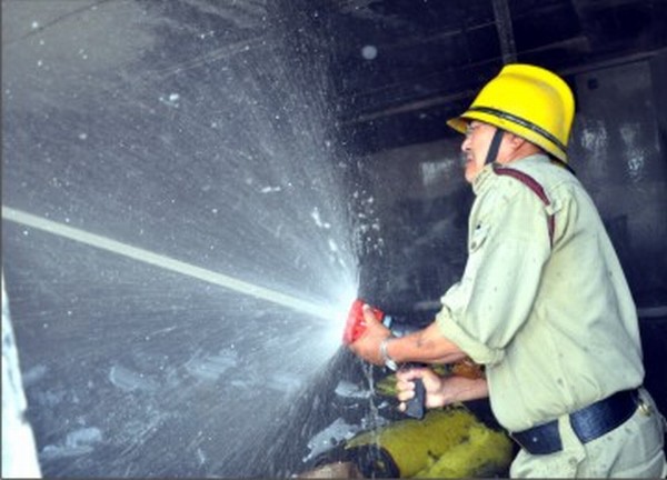 A fireman douses the fire with an extinguisher