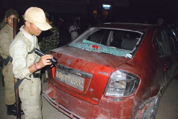 Police personnel inspecting the damaged car