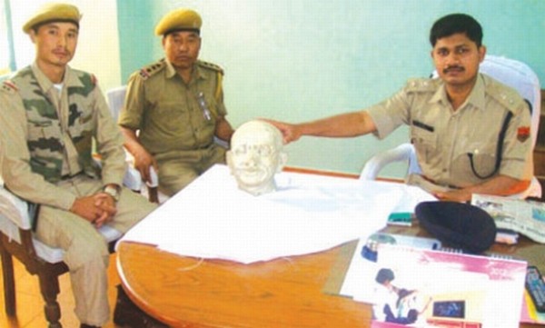 SP Kabib showing the recovered head of Gandhiji's statue