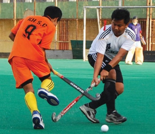 Two players of KHSC (red) and PHAM (white) vying for the ball during a match of the 1st U-18 Boys and Girls State Level Hockey Tournament at Khuman Lampak Hockey Stadium, Imphal