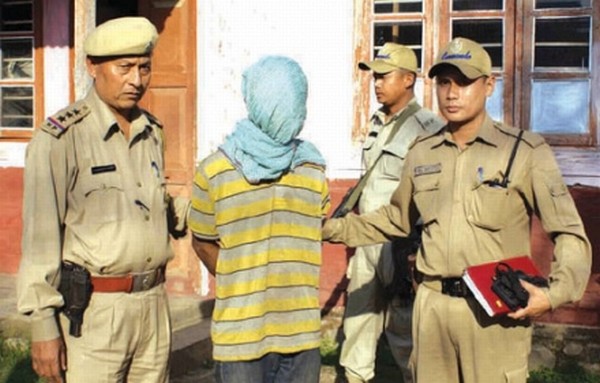 The accused Khelendro being brought to the court with his face covered 