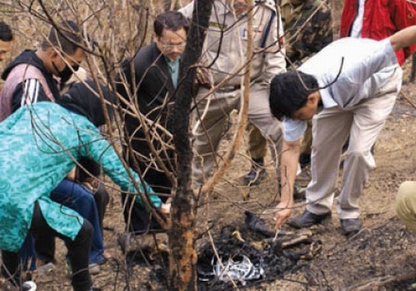 Forensic experts inspecting remnants of the burnt body