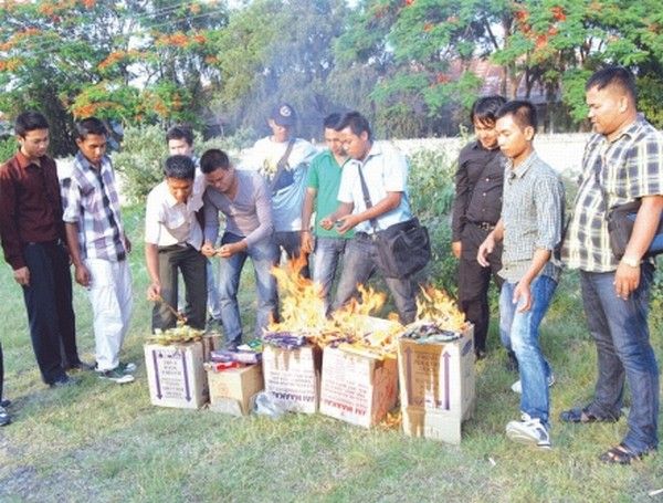 Student agitators consigning to flame goods made in Karnataka which they seized during a drive in market area
