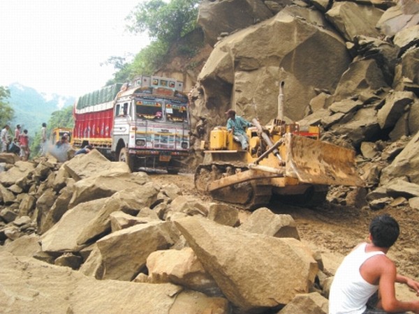 A bulldozer removing the debrises of landslide near Nung Dolan along NH-37