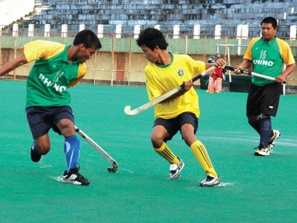 Players of NYC, Ahanthem Leikai (green and yellow) and CRAU, Khamnam Bazar (yellow) vying for the ball during a league match of the 3rd State Level Men's and Women's Open Hockey Tournament