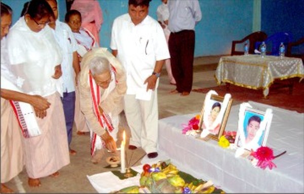 People paying floral tributes to portraits of the two