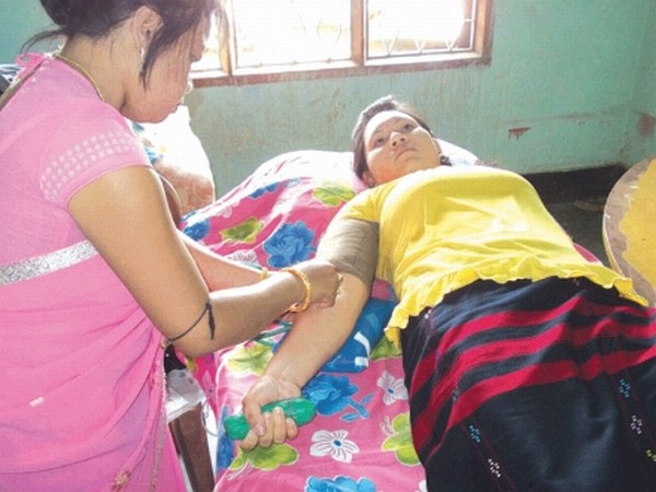 A young woman donating her blood during a blood donation camp held to mark 47th anniversary of AMSU