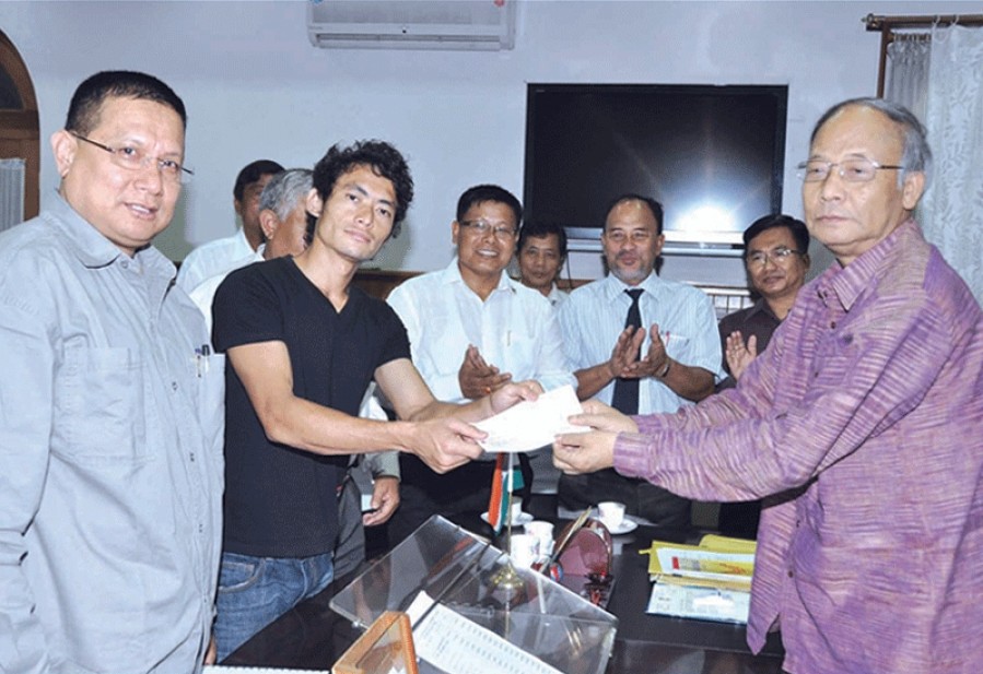 Chief Minister O. Ibobi handing over a cheque of rupees twenty lakhs to Olympian Kh Kothajit