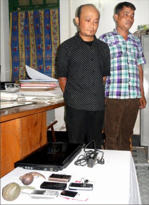 Two of the arrested persons with items seized being paraded.