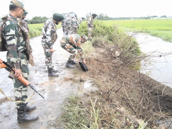 One of the Bomb experts of Assam Rifles examining the blast site as others look on