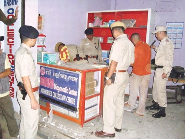 Police inspecting the site of the bomb blast at Babina Diagnosis at Porompat